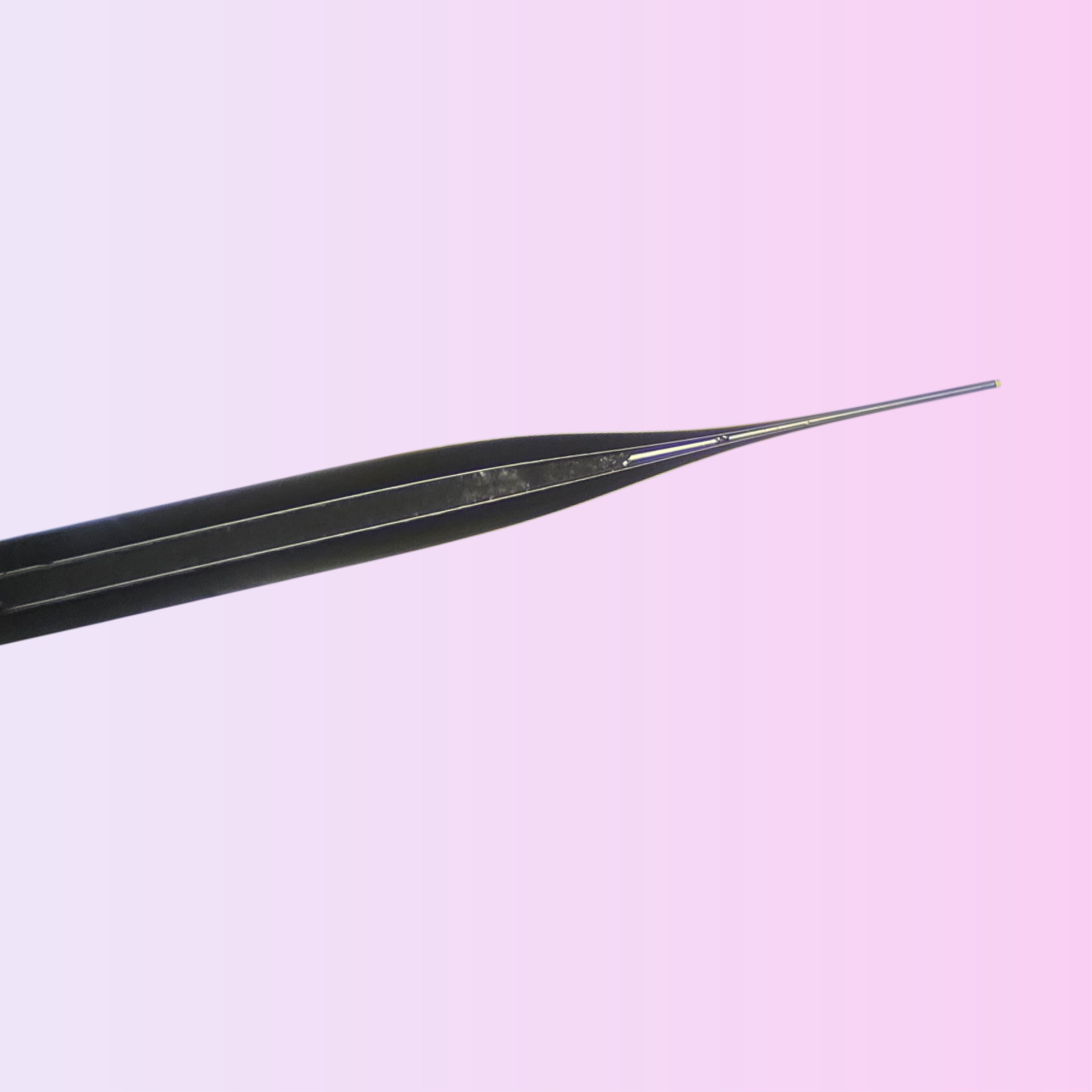 Compact medical instrument featuring a fine needle tip and ergonomic circular handle.